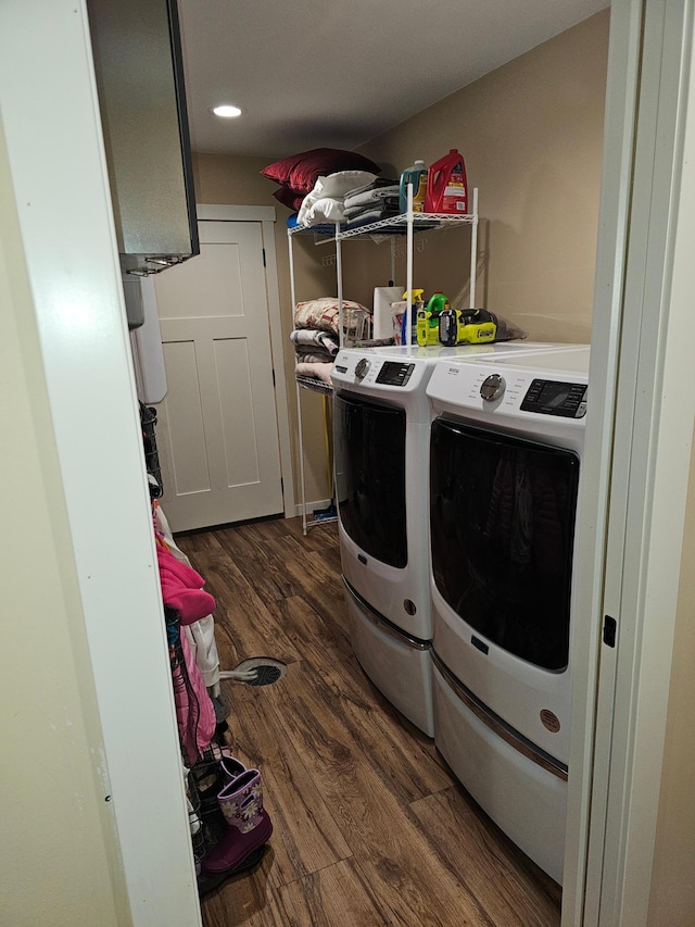 clothes washing area with dark wood-type flooring and washing machine and dryer