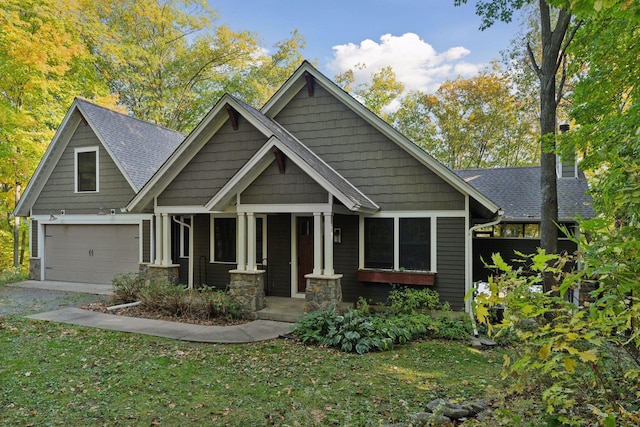 craftsman-style house with a garage, covered porch, and a front yard