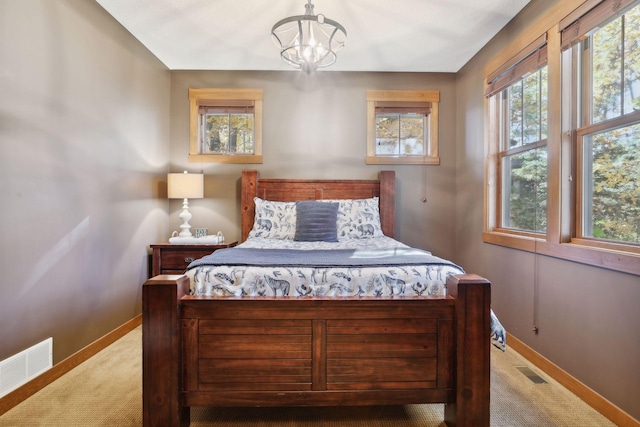 carpeted bedroom with a notable chandelier