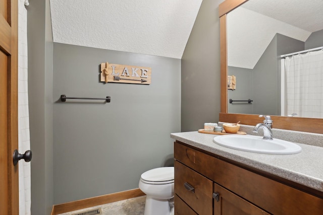 bathroom featuring tile patterned flooring, a textured ceiling, vanity, lofted ceiling, and toilet