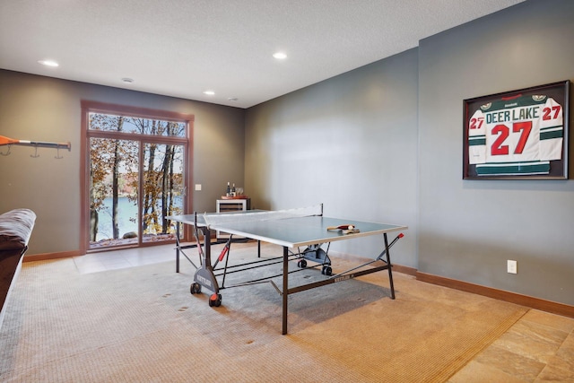 game room featuring a textured ceiling and light tile patterned floors