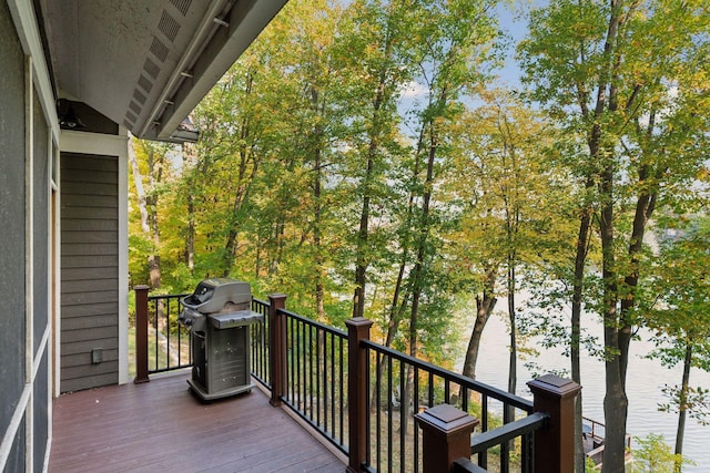 wooden deck with area for grilling and a water view