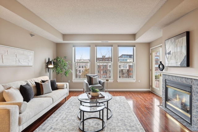 living room with a fireplace, a textured ceiling, and hardwood / wood-style flooring