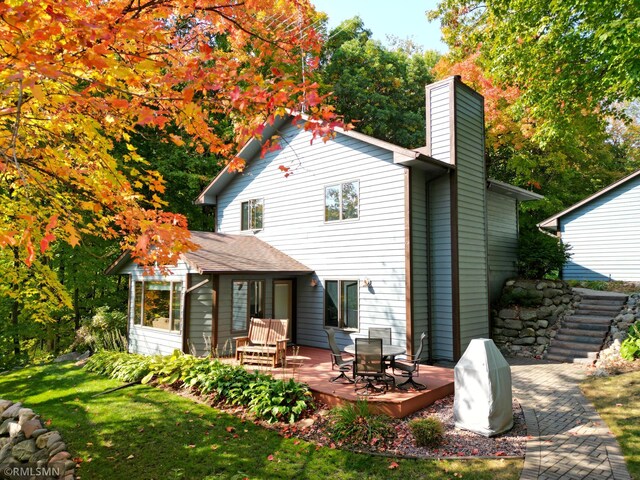 back of house featuring a yard and a deck