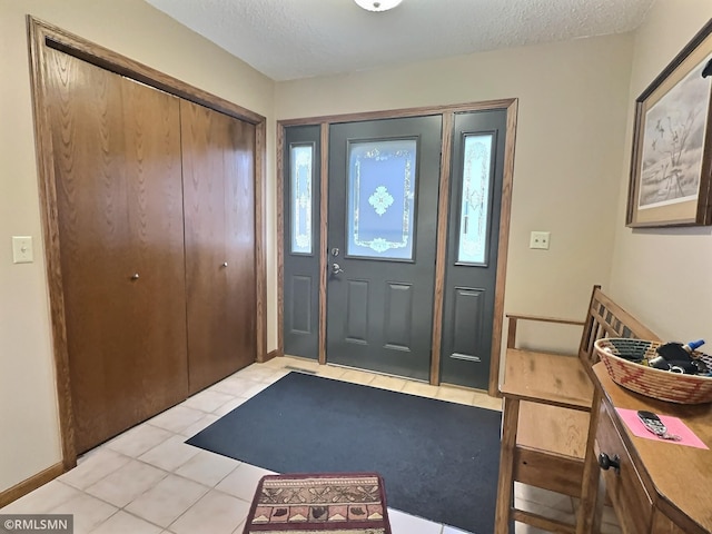 tiled foyer featuring a textured ceiling