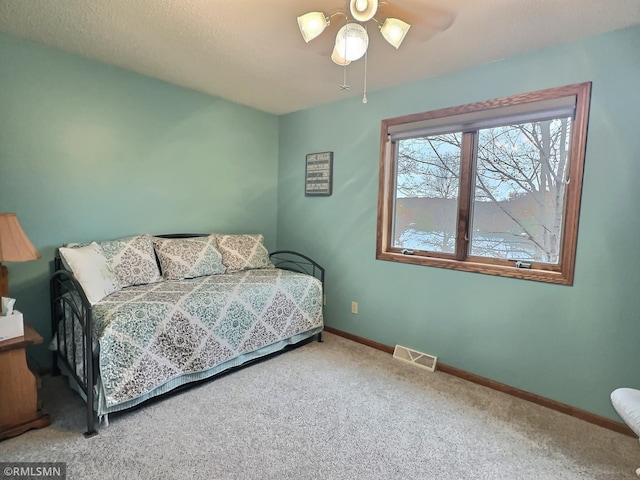 bedroom featuring carpet flooring, a textured ceiling, and ceiling fan