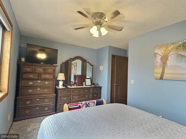 carpeted bedroom featuring a textured ceiling and ceiling fan