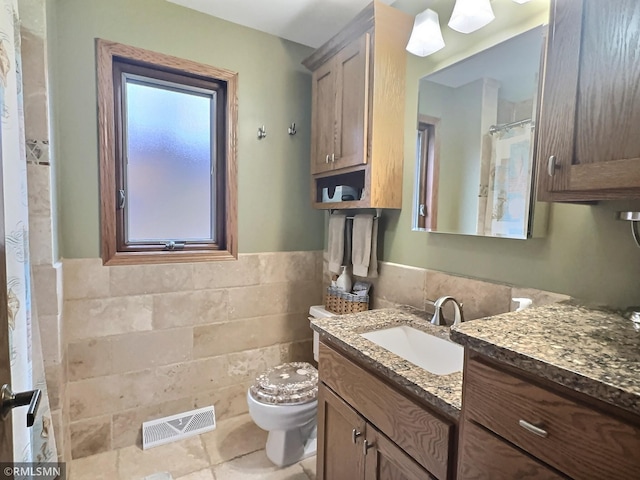 bathroom with toilet, vanity, and tile patterned flooring