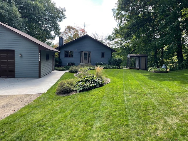 view of yard featuring a garage and an outbuilding