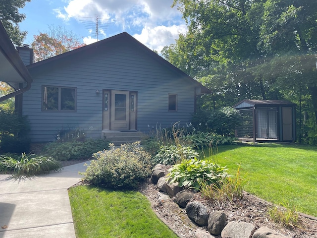 view of front of property with a shed and a front yard