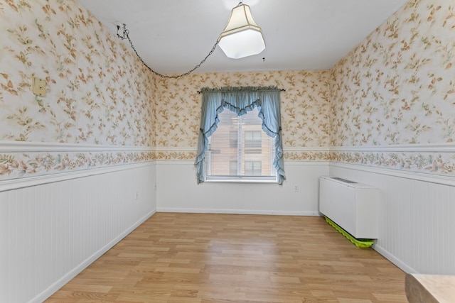 empty room with radiator and light hardwood / wood-style floors