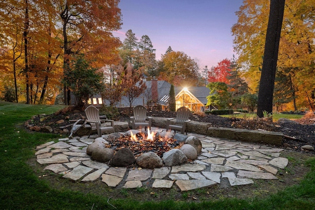 yard at dusk with an outdoor fire pit and a patio