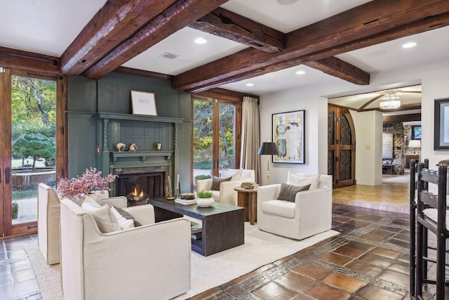 living room featuring beamed ceiling and a wealth of natural light