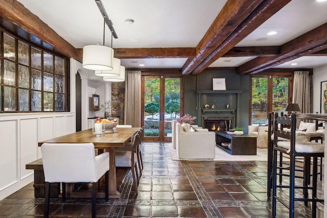 dining space featuring french doors, beamed ceiling, and plenty of natural light