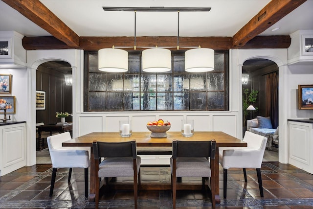 dining space featuring beamed ceiling