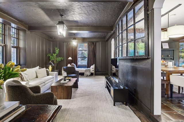 living area with wood walls and beamed ceiling