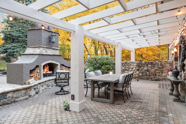 view of patio featuring an outdoor stone fireplace and a pergola