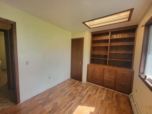 5330 500th St, Kenyon Twp, MN 55946 - unfurnished room featuring a baseboard heating unit, wood finished floors, and a skylight