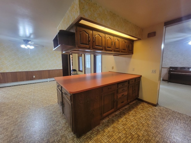 5330 500th St, Kenyon Twp, MN 55946 - kitchen with wallpapered walls, a ceiling fan, a peninsula, baseboard heating, and light countertops