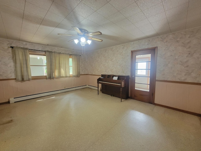 5330 500th St, Kenyon Twp, MN 55946 - spare room with wainscoting, baseboard heating, wallpapered walls, and ceiling fan