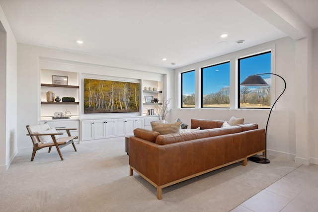 living area with built in shelves, recessed lighting, light colored carpet, and baseboards