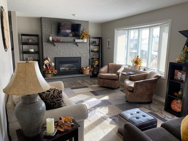 living room featuring a stone fireplace, a textured ceiling, and hardwood / wood-style floors