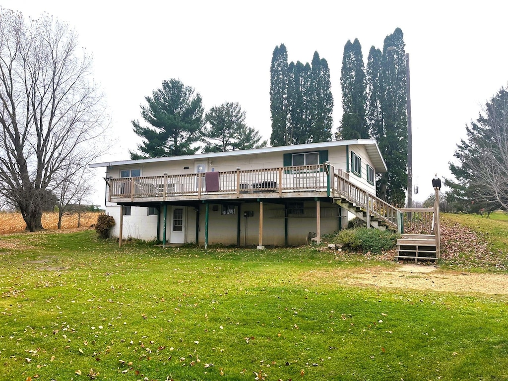 back of property featuring a deck and a yard