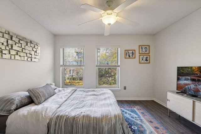 bedroom featuring ceiling fan, dark hardwood / wood-style floors, and a textured ceiling