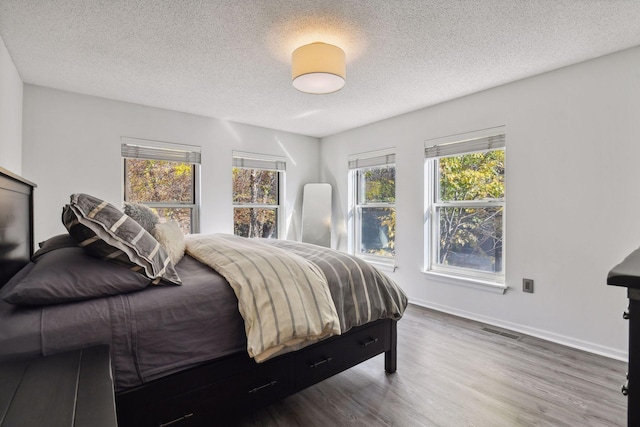 bedroom with hardwood / wood-style flooring and a textured ceiling