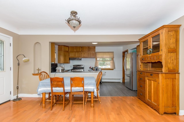 kitchen featuring appliances with stainless steel finishes, a baseboard radiator, and light hardwood / wood-style flooring