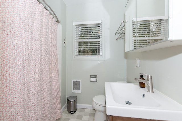 bathroom featuring curtained shower, sink, and toilet