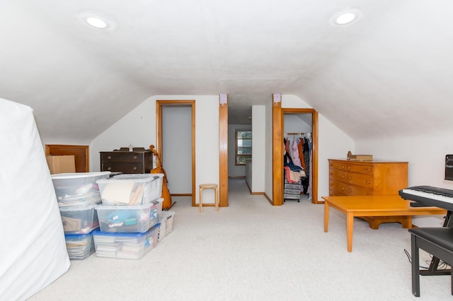 interior space featuring light carpet and vaulted ceiling