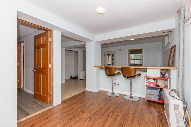 kitchen with wood-type flooring and a kitchen breakfast bar