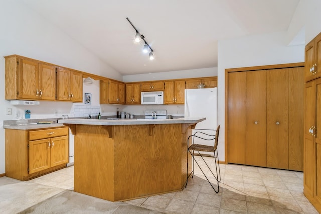 kitchen featuring a kitchen bar, white appliances, a center island, and lofted ceiling