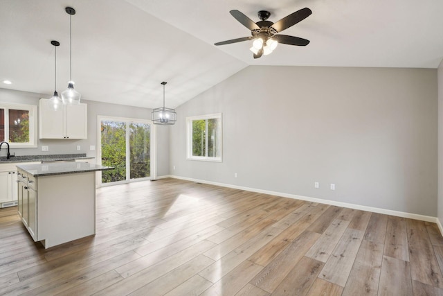 kitchen with a wealth of natural light, lofted ceiling, white cabinetry, and light wood-type flooring