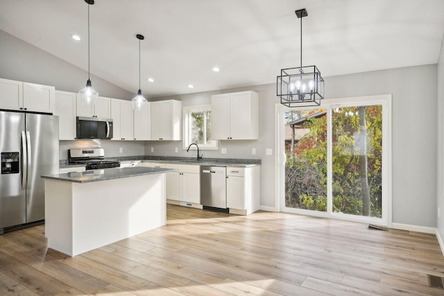 kitchen featuring lofted ceiling, white cabinets, a kitchen island, light hardwood / wood-style flooring, and stainless steel appliances