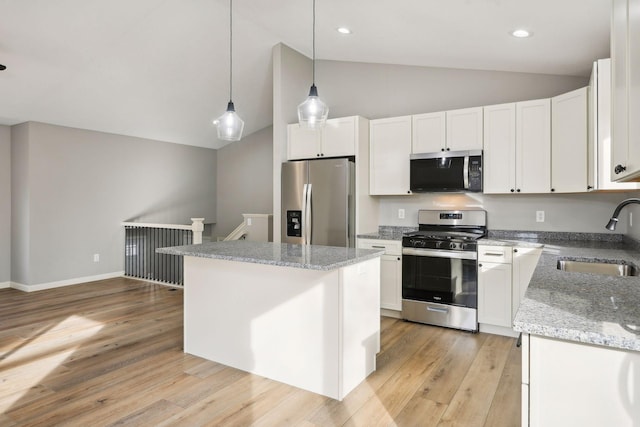 kitchen featuring white cabinets, stainless steel appliances, sink, and vaulted ceiling