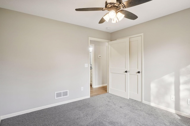 unfurnished bedroom featuring carpet, a closet, and ceiling fan