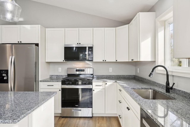 kitchen with a wealth of natural light, lofted ceiling, sink, and appliances with stainless steel finishes