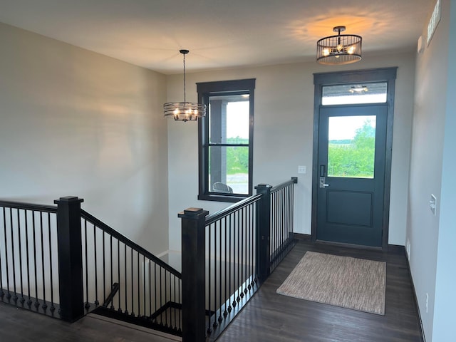 entryway featuring a chandelier, dark wood-type flooring, and a healthy amount of sunlight