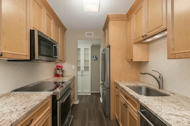 kitchen featuring decorative backsplash, appliances with stainless steel finishes, sink, light brown cabinets, and dark hardwood / wood-style floors