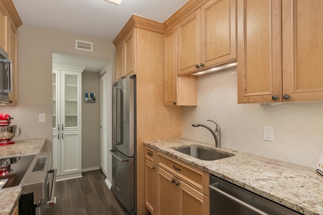 kitchen with dark wood-type flooring, sink, stainless steel appliances, and light brown cabinets