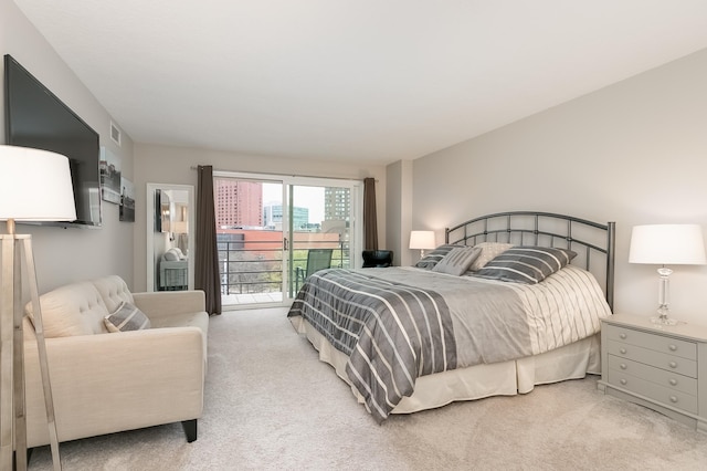 bedroom featuring access to exterior and light carpet