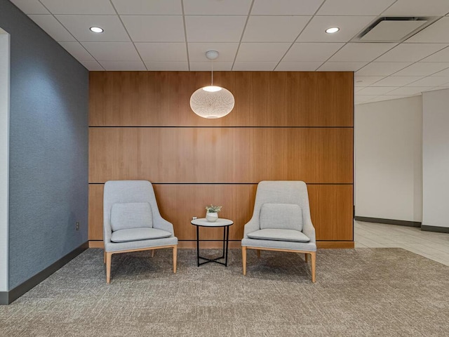 unfurnished room with a paneled ceiling and wood walls