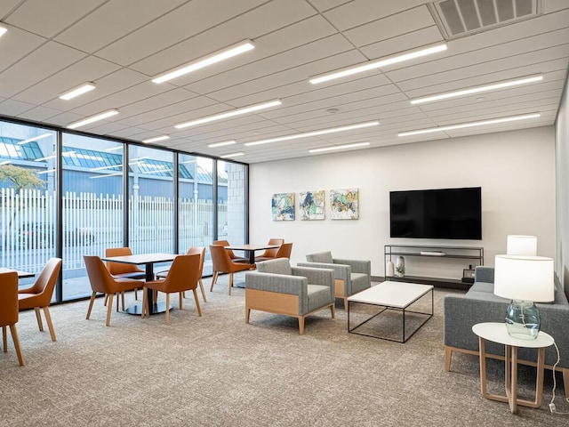 living room featuring carpet flooring and a wall of windows