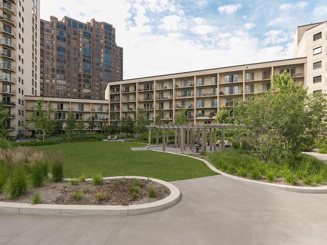 view of home's community featuring a pergola and a lawn