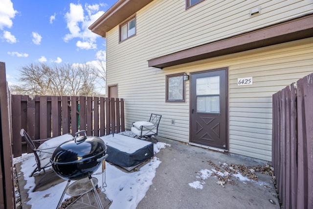 snow covered patio featuring a grill