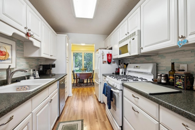 kitchen featuring light hardwood / wood-style flooring, backsplash, sink, white cabinetry, and white appliances