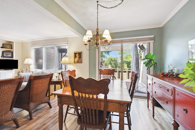 dining area featuring crown molding, a textured ceiling, a chandelier, and light wood-type flooring