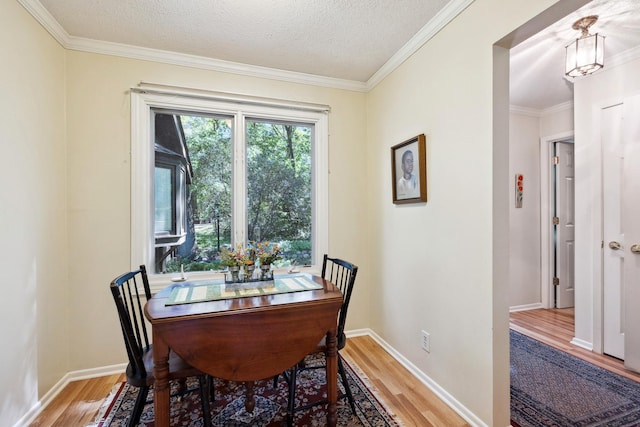 dining room with hardwood / wood-style floors, crown molding, and a textured ceiling